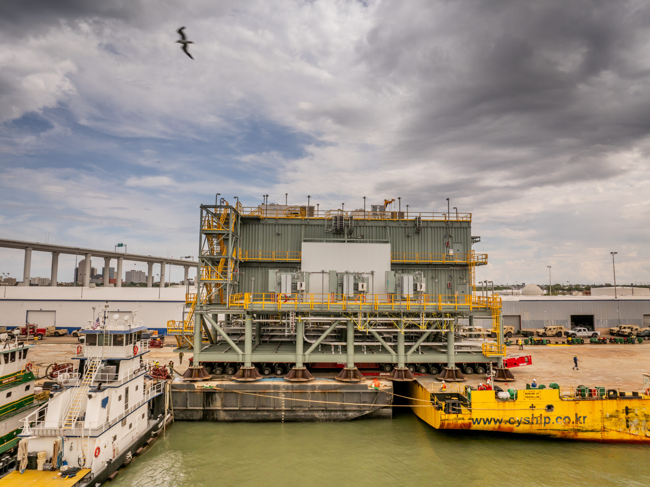 Transfer of the over 25,778 CBM module from the barge to the deck carrier at the Port of Corpus Christi, Texas, USA Transfer of the over 25,778 CBM module from the barge to the deck carrier at the Port of Corpus Christi, Texas, USA