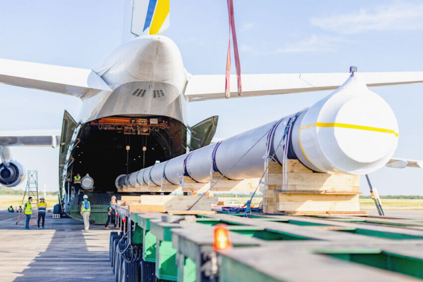 Nine Urgent Air Charters between Thailand and the USA: Cargo loading through the rear cargo door, with one end of the spool lifted by the onboard crane and the other end slowly fed into the aircraft, at U-Tapao Airport, Thailand
